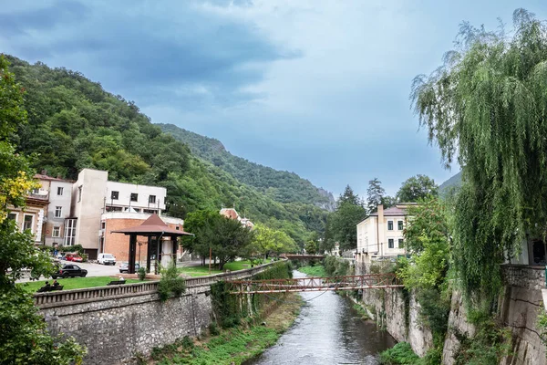 stock image BAILE HERCULANE - SEPTEMBER 15, 2022: Panorama of the river Cerna in Baile Herculane, with individual houses, in the middle of the mountains in the romanian countryside.