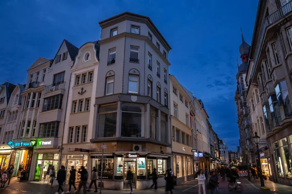 stock image BONN, GERMANY - NOVEMBER 11, 2022: Selective blur on sternstrasse, a medieval street of Bonn at night, with shops and boutiques with a crowd of people passing by in a pedestrian city.