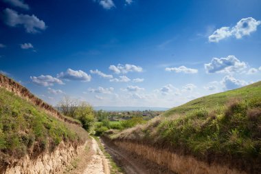 Sırbistan 'ın Voyvodina kentindeki Titelski Breg' in panoraması, baharda mavi gökyüzü ile tarımsal bir arazide, kırsal bir yola sahip..