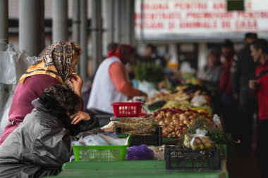 ARAD, ROMANIA - 17 EPTEMBER 2022: Yaşlı bir kadın, yaşlı kadın tüccarlar, bir Romen, Arad pazarında ürün satıyorlar..