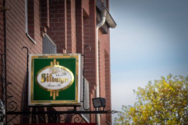 TROISDORF, ALMANY - 13 Kasım 2022: Troisdorf için ana perakendecilerinin üzerindeki Bitburger logosunda seçici bulanıklık. Bitburger bir Alman bira markası, Almanya 'nın en büyük üreticilerinden biri..