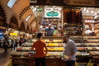 ISTANBUL, TURKEY - MAY 21, 2022: Selective blur on a stall of a merchant selling spices and turkish food ingredients in the Spice Egyptian Bazaar of istanbul, with shops. It's a major landmark & market. clipart