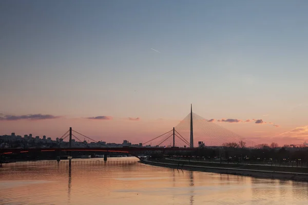 ベオグラードのパノラマは 日没の間に撮影されたサヴァ川 ガゼラ 古いものと新しい鉄道橋 に架かっています ベオグラードはセルビアの首都である — ストック写真