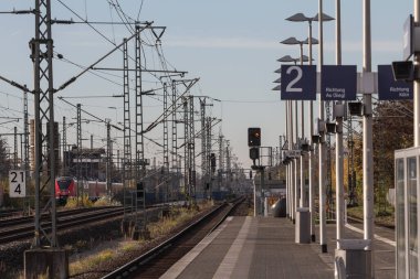TROISDORF, GERMANY - 12 NOVEMBER 2022: Troisdorf tren istasyonunda seçici bulanıklık, Almanya 'nın NRW bölgesinin ulaşım merkezi, arkasında Koln S-bahn Deutsche Bahn treni.