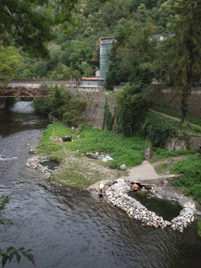 BAILE HERCULANE, ROMANIA - 16 Eylül 2022: Baile Herculane 'de inşa edilmiş bir havuz kaplıcasında tıbbi suyla yıkanan insanların panoraması, Cerna nehri üzerindeki kaplıca ve sülfür sularıyla bilinen bir şehir..