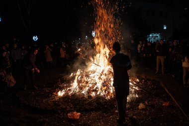 BELGRAD, SERBIA - 6 Ocak 2023: Ortodoks Noel 'inde Belgrad' da Badnjak şubelerini yakan yaşlı bir adam hakkında seçici bulanıklık. Bu geleneksel bir Sırp Noel geleneğidir..