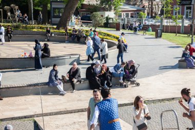 ISTANBUL, TURKEY - MAY 21, 2022: Panorama of kuzguncuk abdullahaga park in Istanbul with young turks, men and women, families, relaxing in spring, on the asian side of the city.