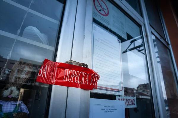 stock image NOVI SAD, SERBIA - MARCH 25, 2023: Selective blur on a red tape from Poreska Uprava Srbije, the tax administration of serbia, indicating that a shop has been on administrative closure for tax fraud.