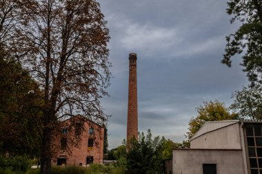 İflas etmiş bir endüstriyel devrimden kalma terk edilmiş bir fabrikanın Kırık Kırmızı tuğla bacasında seçici bulanıklık..