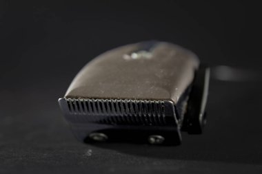 Kirli bir saç makası ya da siyah bir arka planda izole edilmiş bir makasla seçici bir bulanıklık. Saç traşı makinesi kuaförler ve berberler tarafından saç ve sakal kesmek için kullanılır..