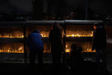 BELGRAD, SERBIA - 6 Ocak 2022: Ortodoks Noelleri sırasında Belgrad 'da badnjak gecesinde kilise mumları yakan Sırp Halkı' nın seçici bulanıklığı. Bu geleneksel bir Sırp Noel geleneğidir..