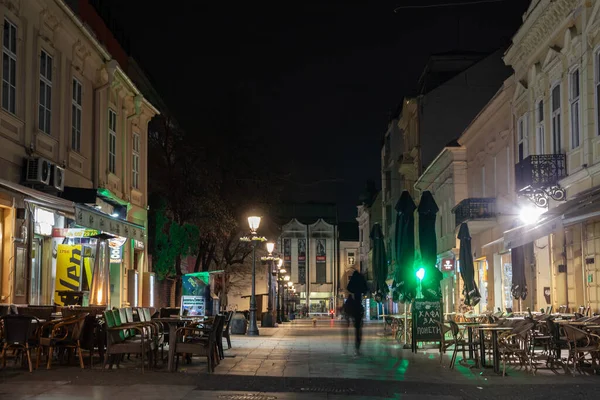 stock image BELGRADE, SERBIA - MARCH 5, 2022: Panorama of the Gospodska ulica, the main street of the city center of Zemun at night with shape of people walking, a pedestrian area. Zemun is suburb of Belgrade.