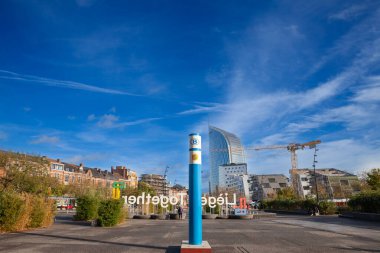 LIEGE, BELGIQUE - 9 Kasım 2022: SNCB NMBS Belçika demiryollarının logosu Pierre Cerdent Meydanı 'nda Liege Guillemins tren istasyonunun önünde arka planında Tour Paradis gökdeleni olan.