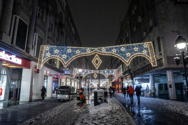BELGRAD, SERBIA -HAZİRAN 10 Ocak 2022: Belgrad 'ın ana yaya sokağı Kneza Mihailova' da seçici bulanıklık, karlı bir kış akşamında Noel süslemeleriyle aydınlatılmış.