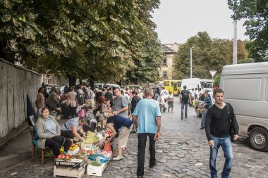 LVIV, UKRAINE - 13 AĞUSTOS 2014: Yaşlı kadınlar grubunda seçici bulanıklık, Babusha, Lviv pazarında (Rinok) müşterilere meyve ve sebze gibi temel ürünler satıyor..