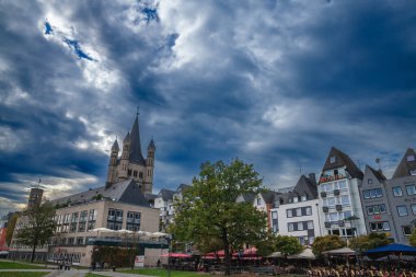 KOLOGNE, ALMANY - 6 Kasım 2022: Koln şehir merkezinde ortaçağ evleri olan Gross Sankt Martin Kirche 'ün ana kulesi. Büyük Aziz Martin Kilisesi, Köln 'de Katolik bir ortaçağ kilisesidir..