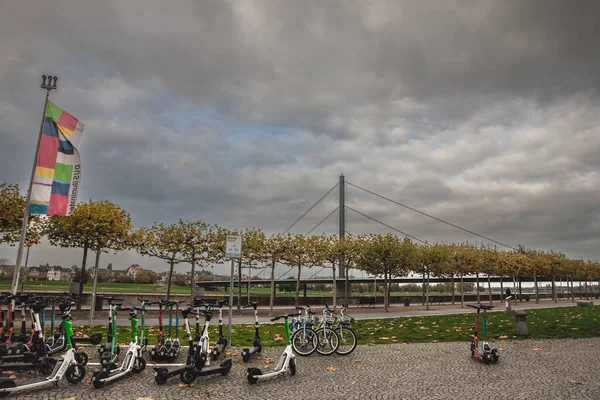 德国杜塞尔多夫市 2022年11月7日 位于德国杜塞尔多夫市Oberkasseler Brucke桥前 一座配有电动车和自行车供出租的共享站的全景 — 图库照片
