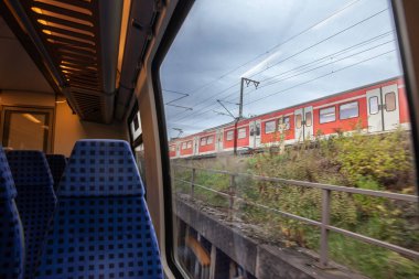 Köln 'de modern Alman bölgesel treninde boş koltuklarda seçici bulanıklık arka planda S-Bahn banliyö treninde hız bulanıklığı, Avrupa tarzı, Alman demiryolu sisteminde, banliyölerde seyahat.