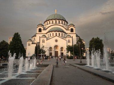 BELGRAD, SERBIA - 10 Temmuz 2023: Saint Sava Katedral Tapınağı 'nda (Hram Svetog Save) seçici bulanıklık ve akşam karanlığında yürüyen Sırp kalabalığı. Bu ortodoks kilisesi Belgrad 'ın başlıca eserleri.