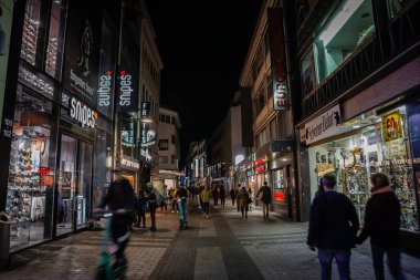 COLOGNE, ALMANY - 5 Kasım 2022: Hohe Caddesi 'nde geceleri dükkanları ve mağazaları olan kalabalık üzerinde seçici bulanıklık. Hohe Caddesi, Eski Köln 'ün ana caddesi, alışveriş caddesi..