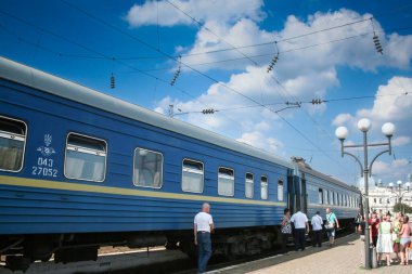ODESSA, UKRAINE - 6 AĞUSTOS 2014: Odessa tren istasyonunda bir gecelik Ukrayna tren yolunun (ukrzaliznytsia) önünden geçen yolcularda seçici bulanıklık.
