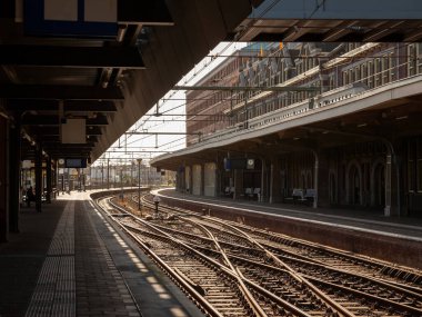 Gün batımında Hollanda demiryollarına ait Maastricht tren istasyonunun raylarında ve platformlarında seçici bulanıklık. Maastricht tren istasyonu bir ulaşım merkezidir..