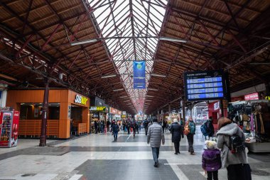 BUCHAREST, ROMANIA - 15 Mart 2023: Bükreş, Romanya 'nın ana tren istasyonu Gara de Nord' un ana kalkış salonu, bir yolcu kalabalığı bir yolcu gemisinin yanından geçiyor.