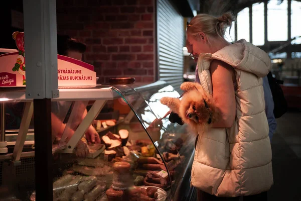 Riga Latvia 2023年8月23日 在里加中央市场中央市场的肉铺和肉铺 有选择地模糊了一个女人 一个客户 拿着一只小狗 购买肉 — 图库照片