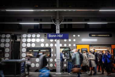 BONN, GERMANY - NOVEMBER 7, 2022: Bonn Hbf platformuna koşan kalabalık yolcular için seçici bulanıklık, Bonn Ana Tren İstasyonu (Hauptbahnhof) olarak da bilinir. Burası Bonn 'un ana tren istasyonu..