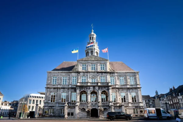 MAASTRICHT, NETHERLANDS - 10 Kasım 2022: stadhuis maastricht, Maastricht belediye binası, güneşli bir gün batımında mavi gökyüzü. Şehrin ana simgesi, 17. yüzyılda tasarlandı..