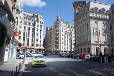 BUCHAREST, ROMANIA - 16 Mart 2023: Bükreş taksisi bir caddenin ortasında tipik Romen taksisi sarısı renginde, taksiye binmeye ve şehir merkezinde taksiye binmeye hazır..