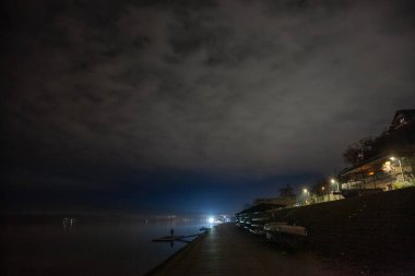 Sırbistan 'ın Belgrad banliyösü Zemunski Kej' deki Dabube nehrinin karanlık bir manzarasında seçici bulanıklık. Zemun ikonik bir turistik yerdir..