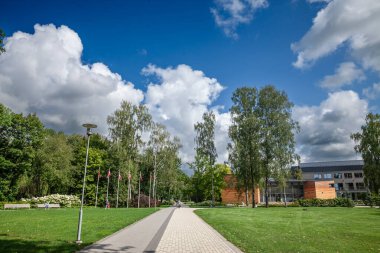 SIGULDA, LATVIA - 26 AĞUSTOS 2023: Sigulda şehir merkezinde yeşil çimenli ve modern mimarisi olan yaya yolunun panoraması. Sigulda Letonya 'nın büyük bir şehri ve turistik bir yerdir..