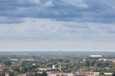 Riga 'nın kenar mahallelerinin hava manzarası, birkaç bina ve bir ufuk dolusu Letonya ormanı, tipik Baltık ülkelerinden, bulutlu bir gökyüzü üzerinde.