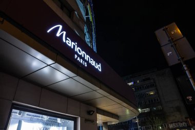 BUCHAREST, ROMANIA - 22 Mart 2023: Marionnaud logosu gece Bükreş şehir merkezindeki ana dükkanlarının önünde. Marionnaud bir Fransız kozmetik, parfüm ve kişisel bakım ürünleri satıcısıdır..