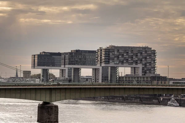 KOLOGNE, ALMANY - 6 Kasım 2022 Ren Nehri 'nin önündeki alacakaranlıkta Rheinauhafen gökdelen kulesinin panoraması. Rheinauhafen, Köln 'de bir iş parkı ve kentsel yenilenme projesi..