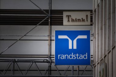 DORTMUND, ALMANY - 13 Kasım 2022: Randstad logosu Dortmund için ana ofislerinin önünde. Randstad, personel, geçici ve işe alım ve insan kaynakları danışmanlığında uzmanlaşmış bir Hollandalı grup..