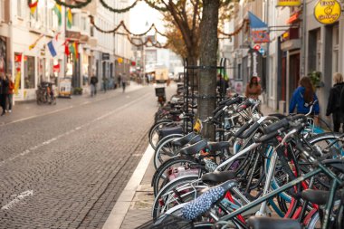 MAASTRICHT, NETHERLANDS - 9 Kasım 2022: Bisikletli seçici bulanıklık, Maastricht şehir merkezinde, yaya yolu kenarında bir bisiklet parkına park edilmiş. Bisiklet ve bisikletler Hollanda 'nın bir sembolüdür..