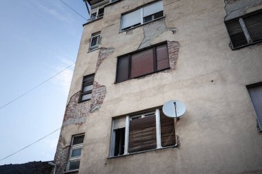 Uydu anteni ve UHF antenleri konut binasının çürüyen ön cephesinde sergileniyor. Bunlar iletişim ve uydu televizyon alıcıları için kullanılır..