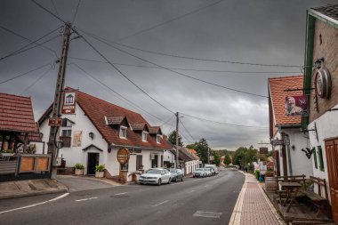 VILLANY, HUNGARY - 23 Eylül 2023: Bulutlu bir öğleden sonra, Villany 'nin ana caddesi olan Baross Gabor Utca caddesi. Villany Güney Hungary 'de şarapla bilinen bir köydür..