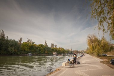 PANCEVO, SERBIA - 7 Ekim 2023: Bir balıkçı, Pancevo Rıhtımı 'nda, tamis nehrinde, bir sonbahar öğleden sonrasında balık tutuyor..