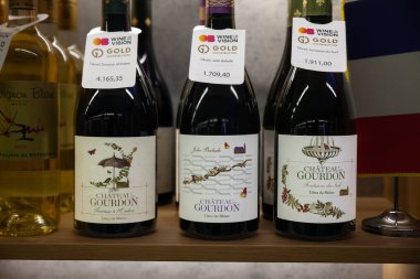 BELGRAD, SERBIA - 18 Kasım 2023: Sırbistan 'ın Belgrad kentindeki bir şarap dükkanında satılık çok sayıda Fransız şarabı, Cotes du Rhone Chateau Gourdon, kırmızı şarap şişesi. Fransa çok şarap ihraç eder..