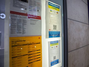 COLOGNE, GERMANY - NOVEMBER 6, 2022: Ukrayna 'da savaş nedeniyle sığınma talebinde bulunan Ukraynalı mültecilere yardım ve yardım koşullarını anlatan Ukraynalı & Almanca bilgi broşüründe seçici bulanıklık.