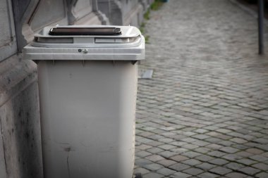 Avrupa 'da Liege' de yaya caddesinde duran gri çöp konteynırında seçici bulanıklık, atık imhası, çöp yönetimi ve geri dönüşüm için kullanılıyor.