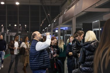 BELGRAD, SERBIA - 19 Kasım 2023: Belgradda Sırp bir adamın kırmızı şarap tatması ve içmesi konusunda seçici bulanıklık. Sırbistan büyük bir alkol ve şarap üreticisi.