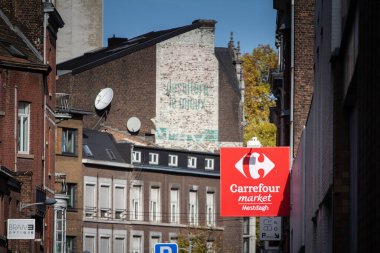 LIEGE, BELGIUM - 9 Kasım 2022: Carrefour market logosu Liege şehir merkezindeki yerel süpermarketlerinin önünde. Avrupa 'nın önde gelen perakendecilerinden Carrefour Belgique Group' a ait..