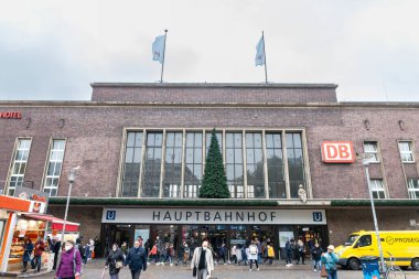 DÜKSELDORF, GERMANY - 7 Kasım 2022: Düsseldorf Hbf veya Alman şehrinin ana demiryolu merkezi Düsseldorf Hauptbahnhof 'un ön cephesinden yürüyen yolcular.