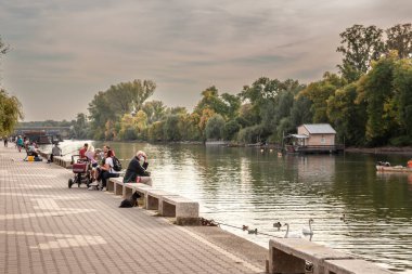PANCEVO, SERBIA - 7 Ekim 2023: Pancevo Rıhtımı 'ndaki Tamis nehrinin kenarında oturan yaşlı bir adam, 19 Coronavirus salgınında solunum maskesi takıyor..