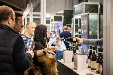 BELGRAD, SERBIA - 19, 223: Belgrad 'da kırmızı şarap tadan ve içen bir Sırp' ın bardağına kırmızı şarap dolduran garsona seçici bulanıklık. Sırbistan büyük bir alkol ve şarap üreticisi