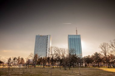 BELGRAD, SERBIA - 24 Ocak 2024: Yeni Belgrad 'daki Usce Kuleleri, Usce 1 ve 2 (Novi Beograd) akşam karanlığında. Bunlar karışık bir kullanılmış yüksek katlı gökdelen ve Belgrad 'ın simgesi ve simgesi..